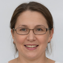 Joyful white adult female with medium  brown hair and grey eyes