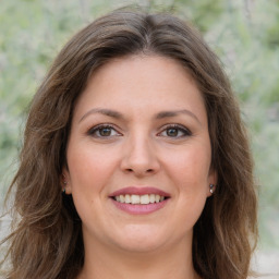 Joyful white young-adult female with long  brown hair and green eyes