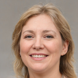 Joyful white adult female with medium  brown hair and grey eyes