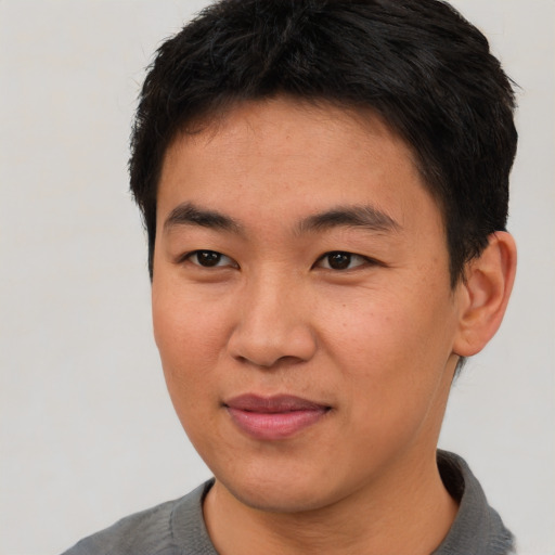 Joyful asian young-adult male with short  black hair and brown eyes