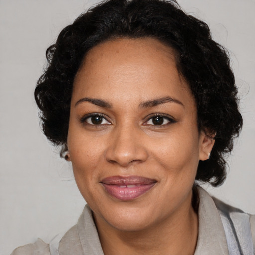 Joyful black adult female with medium  black hair and brown eyes