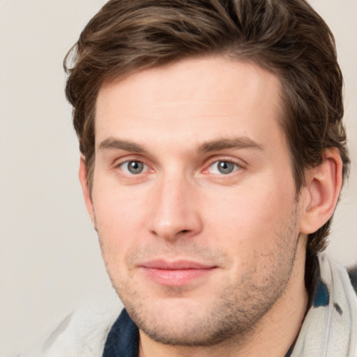 Joyful white young-adult male with short  brown hair and grey eyes