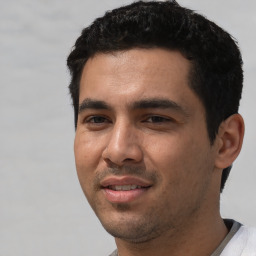 Joyful white young-adult male with short  black hair and brown eyes