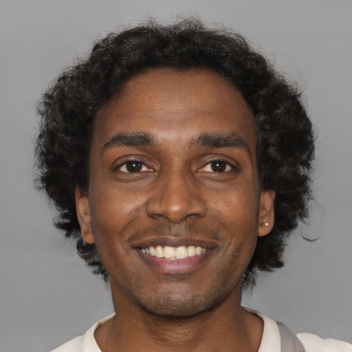 Joyful black young-adult male with short  brown hair and brown eyes