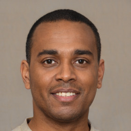 Joyful latino young-adult male with short  brown hair and brown eyes