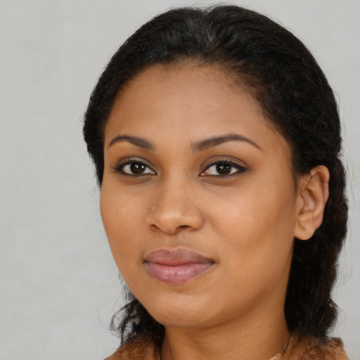 Joyful black young-adult female with long  brown hair and brown eyes