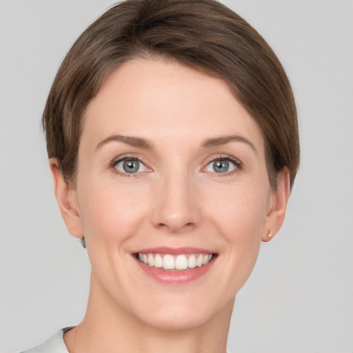 Joyful white young-adult female with short  brown hair and grey eyes