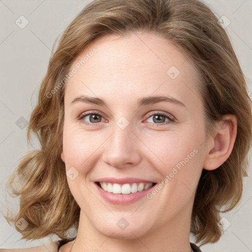 Joyful white young-adult female with medium  brown hair and green eyes