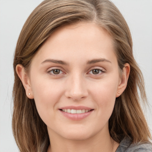 Joyful white young-adult female with long  brown hair and grey eyes