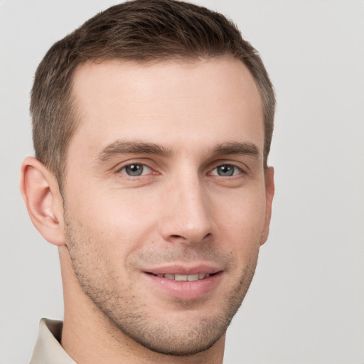 Joyful white young-adult male with short  brown hair and grey eyes