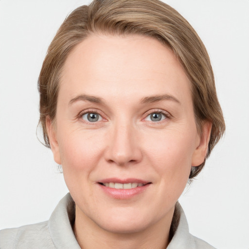 Joyful white adult female with medium  brown hair and grey eyes