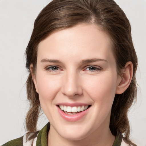 Joyful white young-adult female with medium  brown hair and grey eyes