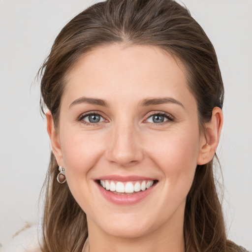 Joyful white young-adult female with long  brown hair and grey eyes