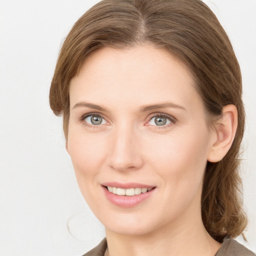 Joyful white young-adult female with medium  brown hair and green eyes