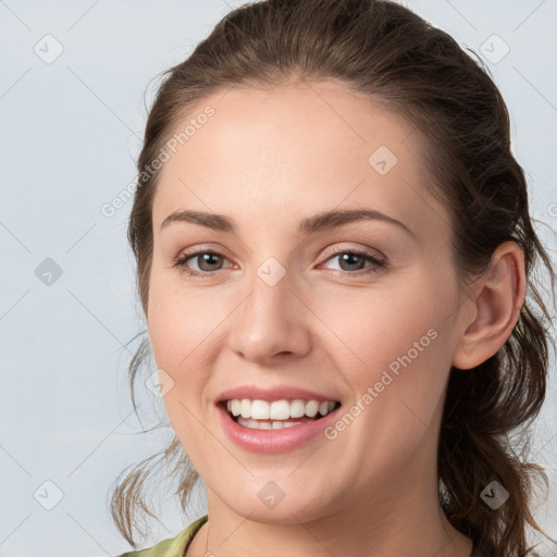 Joyful white young-adult female with medium  brown hair and grey eyes