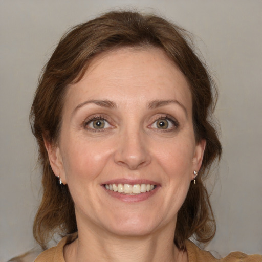 Joyful white adult female with medium  brown hair and green eyes