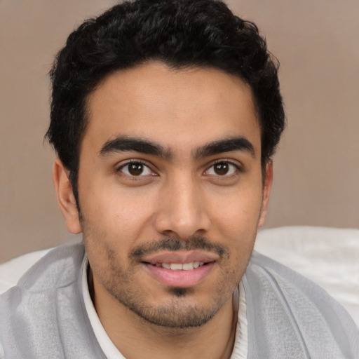 Joyful latino young-adult male with short  black hair and brown eyes