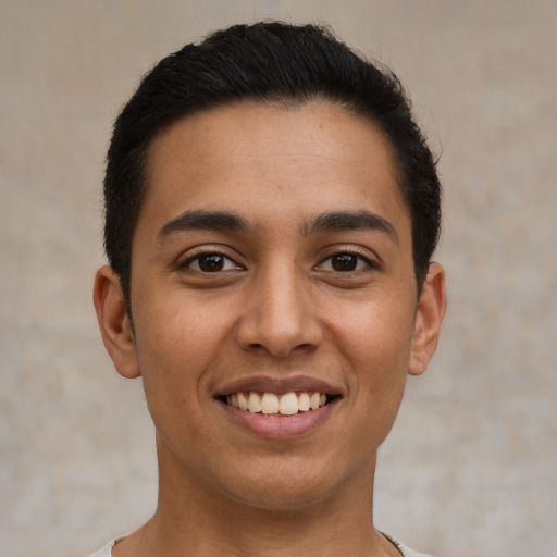 Joyful latino young-adult male with short  brown hair and brown eyes