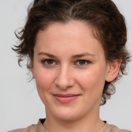 Joyful white young-adult female with medium  brown hair and green eyes