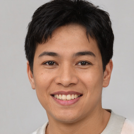 Joyful asian young-adult male with short  brown hair and brown eyes