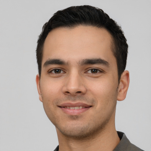 Joyful latino young-adult male with short  black hair and brown eyes