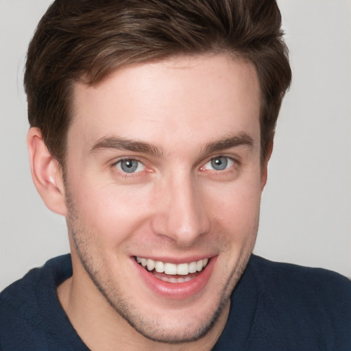 Joyful white young-adult male with short  brown hair and grey eyes