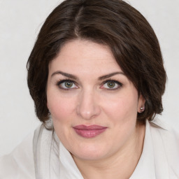 Joyful white young-adult female with medium  brown hair and green eyes