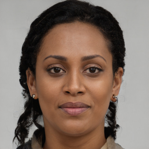 Joyful black young-adult female with long  brown hair and brown eyes
