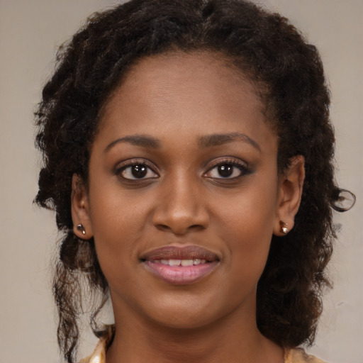 Joyful black young-adult female with long  brown hair and brown eyes