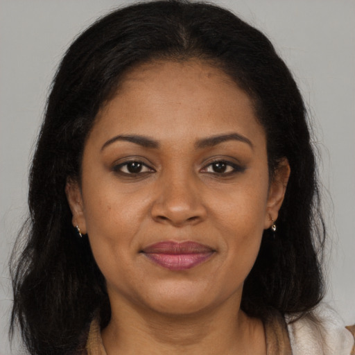 Joyful black adult female with long  brown hair and brown eyes