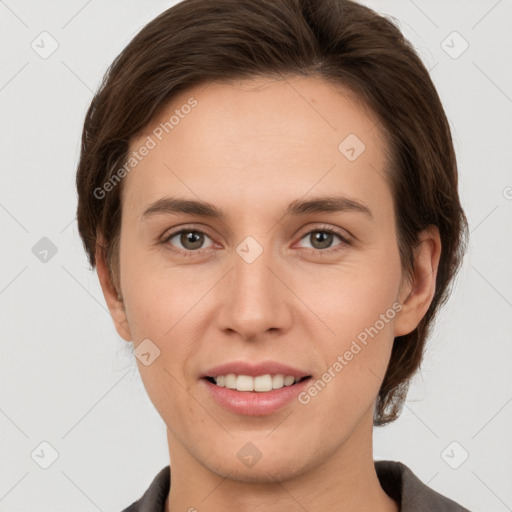 Joyful white young-adult female with short  brown hair and grey eyes