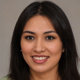 Joyful latino young-adult female with long  brown hair and brown eyes