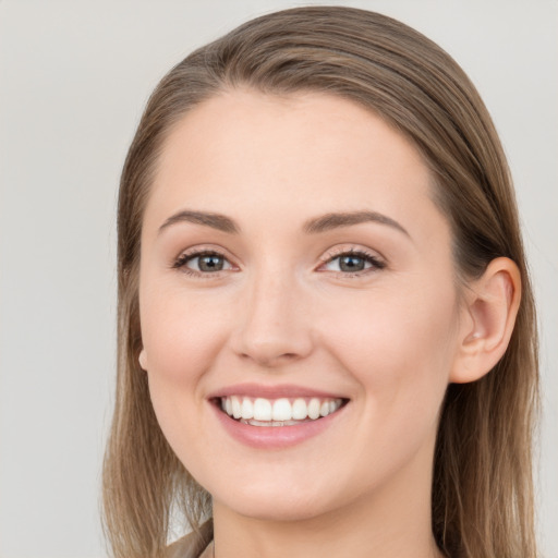 Joyful white young-adult female with long  brown hair and grey eyes