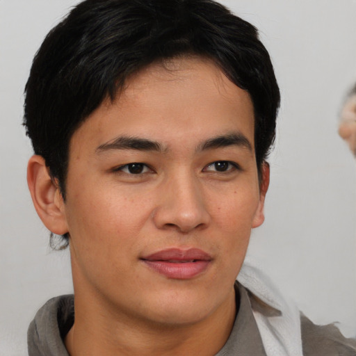 Joyful asian young-adult male with short  brown hair and brown eyes