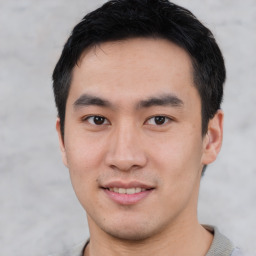 Joyful asian young-adult male with short  black hair and brown eyes