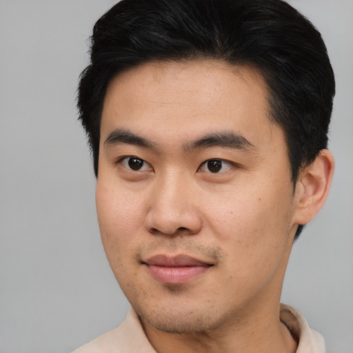 Joyful asian young-adult male with short  black hair and brown eyes