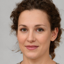 Joyful white young-adult female with medium  brown hair and green eyes