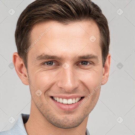 Joyful white young-adult male with short  brown hair and grey eyes