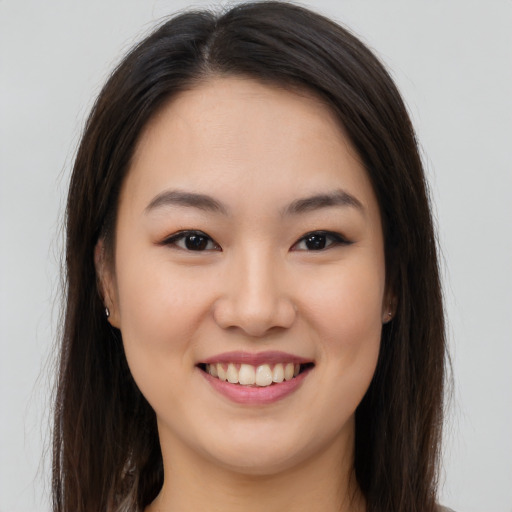 Joyful asian young-adult female with long  brown hair and brown eyes