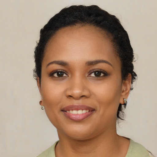 Joyful black young-adult female with short  black hair and brown eyes