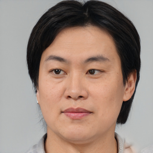 Joyful asian young-adult male with medium  brown hair and brown eyes