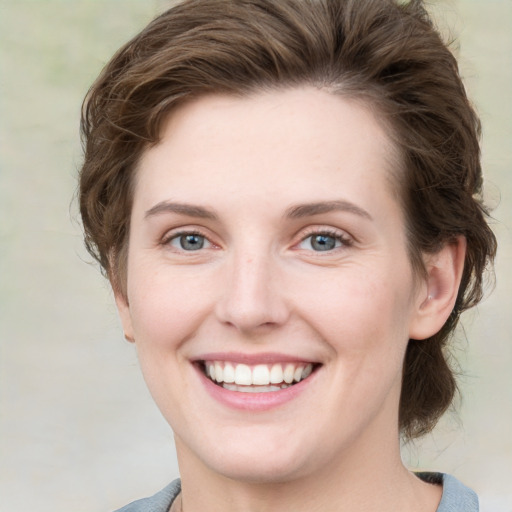 Joyful white young-adult female with medium  brown hair and green eyes