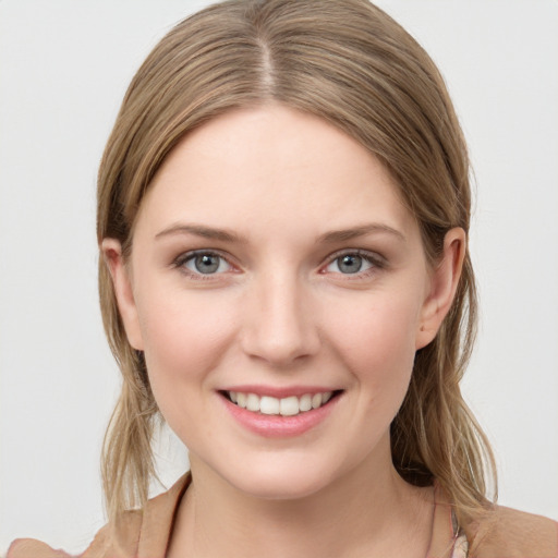 Joyful white young-adult female with medium  brown hair and grey eyes