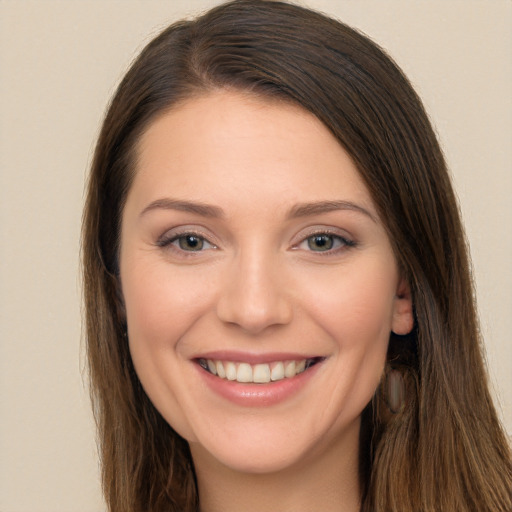 Joyful white young-adult female with long  brown hair and brown eyes