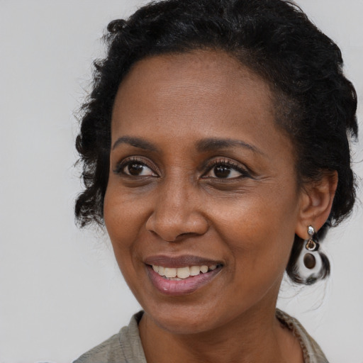 Joyful black adult female with medium  brown hair and brown eyes