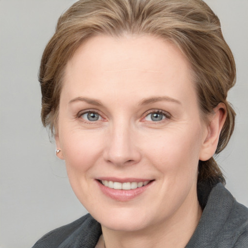 Joyful white adult female with medium  brown hair and blue eyes