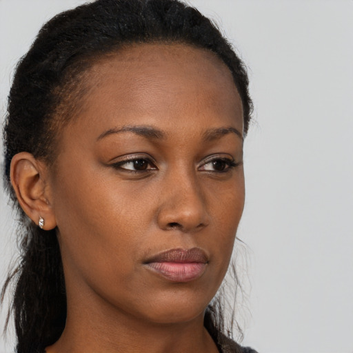 Joyful black young-adult female with long  brown hair and brown eyes