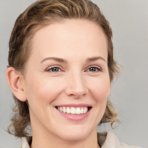 Joyful white young-adult female with medium  brown hair and grey eyes