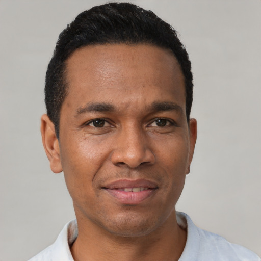 Joyful latino young-adult male with short  black hair and brown eyes