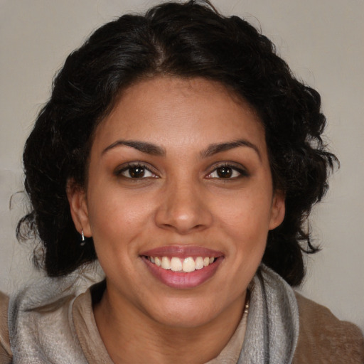 Joyful black young-adult female with long  brown hair and brown eyes